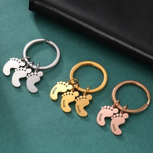 Customized stainless steel baby feet keychains in silver, gold, and rose gold finishes