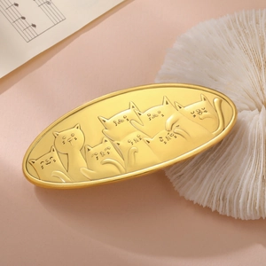 Detailed macro shot of vintage gold cat hair clip with embossed feline pattern
