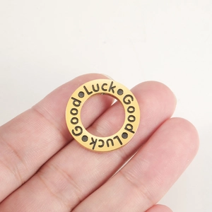 Detailed close-up of a gold-plated Good Luck pendant ring held to show its compact size