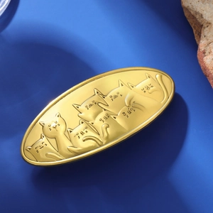 Detailed relief of six matte golden cats on a vintage style metal hair clip surface