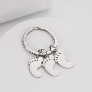 Detail of silver baby feet charms on a stainless steel keychain with high-quality finish