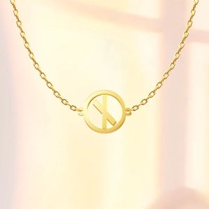 Close-up of a 18K gold-plated Viking rune pendant on a delicate O-chain necklace