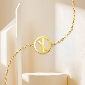 Macro detail of 18K gold plated stainless steel necklace featuring a Runes letter X pendant