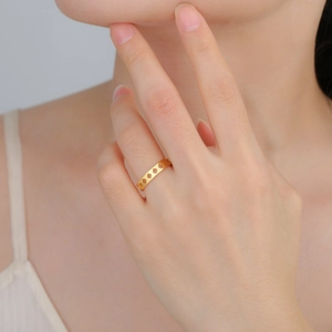 Primer plano de anillo de rombos huecos chapado en oro de 18K con acabado mate