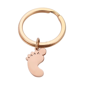Macro detail of rose gold baby feet pendant keychain with polished metallic finish