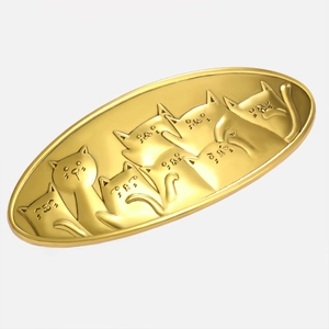 Detail of a vintage golden alloy hair clip with embossed cartoon cat motifs