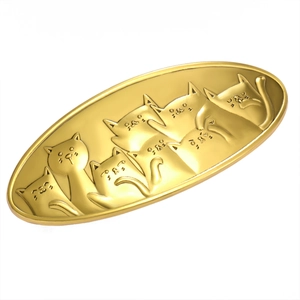 Golden oval metal jewelry tray featuring embossed cartoon cat patterns and glossy finish