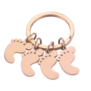 Detailed view of rose gold steel keychain with four cute hollowed foot pendants