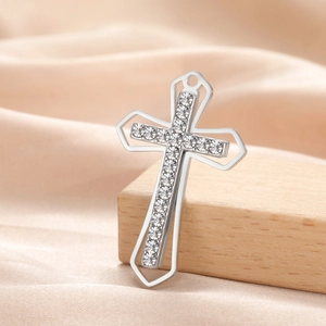 Detailed close-up of a vintage stainless steel cross pendant with sparkling crystal inlay