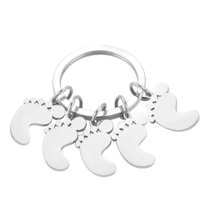 Polished stainless steel keychain featuring five cute baby feet pendants on a circular ring
