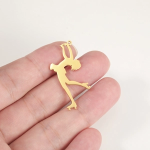 Detailed view of an 18K gold-plated roller skate pendant held by hand for scale