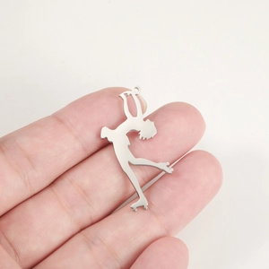 Macro detail of polished stainless steel female roller skater pendant for jewelry making
