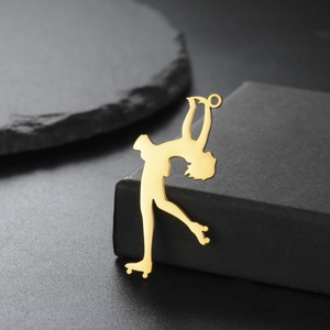 Detail of 18K gold plated roller skater pendant on elegant black stone background