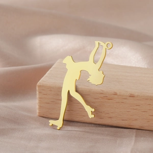 Detail of 18K gold plated stainless steel roller skater pendant on a silk background