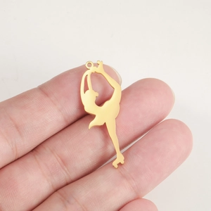 Close-up of 18K gold plated stainless steel roller skater pendant held in hand for scale