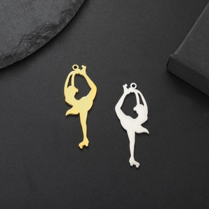 Detail of gold and silver roller skater silhouette pendants on black stone surface