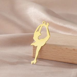 Detailed close-up of 18K gold plated ice skater pendant with smooth metallic texture