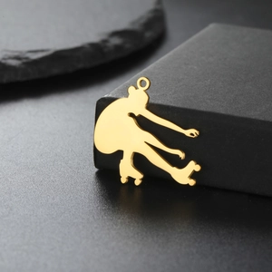Macro shot of 18K gold plated roller skater pendant with high polished metal surface