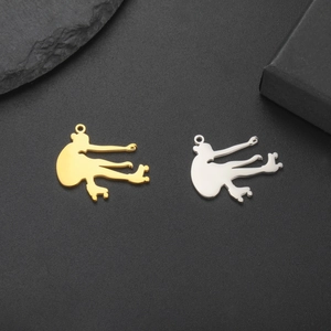 Close-up of 18K gold and silver roller skate pendants on a textured black surface