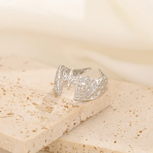 Macro shot of silver-colored bat ring featuring irregular lava texture and wave edges