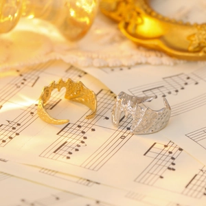 Detail of molten texture stainless steel ring in gold and silver on vintage sheet music