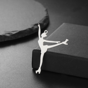 Detailed view of an 18K gold plated roller skater pendant on a textured black stone