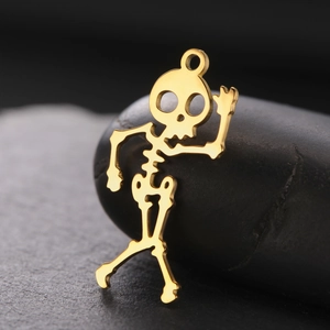 Macro detail of 18K gold plated skeleton charm with intricate hollowed craftsmanship
