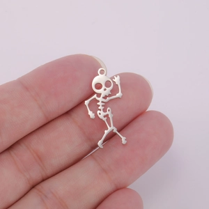 Detailed macro view of a silver skeletal charm being held to show small scale and size
