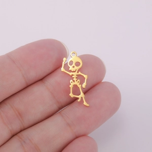 Golden stainless steel skeleton pendant for DIY jewelry held by hand to show size