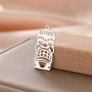 Macro shot of silver titanium steel clown mask pendant with hollow Polynesian design