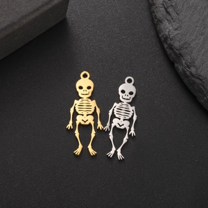 Macro shot of gold and silver hollow skull pendants for jewelry making on rock base