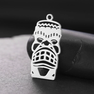 Detailed macro view of a silver stainless steel hollow Frankenstein mask pendant on stone