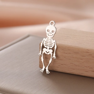 Macro shot of silver hollow skull charm on wooden stand with satin background detail