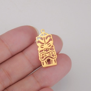 Macro view of a 18K gold plated hollow Joker mask pendant with detailed tribal engraving
