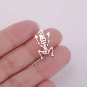 Close-up of dancing skeleton pendant with top ring held by fingers to show product size