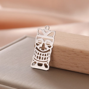 Detail of hollowed-out titanium steel joker mask pendant with polished silver finish