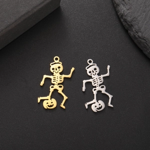 Macro detail of skeleton on pumpkin charms in 18K gold and silver stainless steel