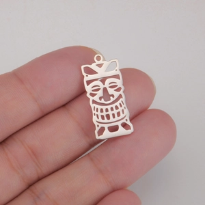 Macro shot of silver hollow tribal tiki mask pendant in titanium steel finish