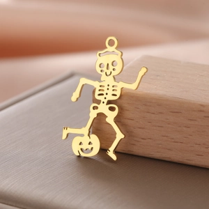 Macro shot of gold-plated hollow skeleton pendant on pumpkin for Halloween jewelry