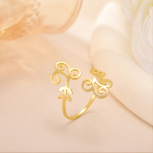 Detailed view of matte gold open ring featuring intricate symmetrical vine patterns