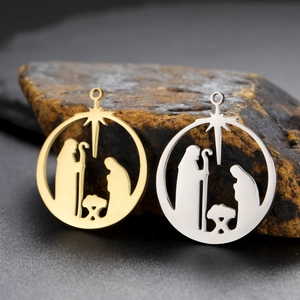 Detailed view of hollow round Nativity scene pendants in gold and silver stainless steel