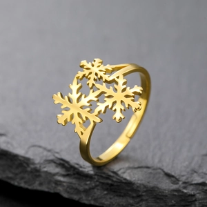 Macro detail of golden snowflake cutout ring on a textured dark stone surface
