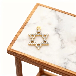 Detailed view of a gold-plated Star of David pendant with inlaid zircons on a marble stand