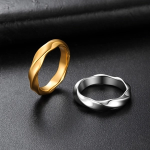 Close-up of twisted rope texture on gold and silver stainless steel rings on leather