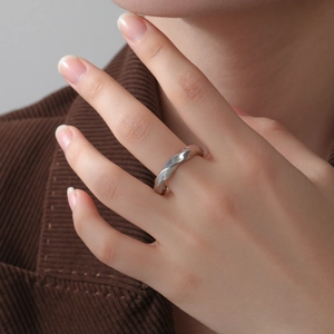Macro shot of a silver twisted spiral ring featuring a modern textured molten metal design