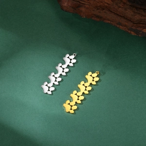 Detailed view of vertical gold and silver cat paw print pendants on a textured background