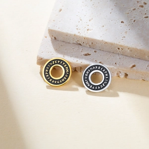 Macro shot of Viking Rune charms in gold and silver finish with black enamel inlays