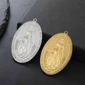 Detail of gold and silver Virgin Mary oval pendants with embossed religious reliefs