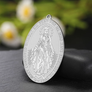 Detailed close-up of oval silver stainless steel Virgin Mary pendant with prayer engraving