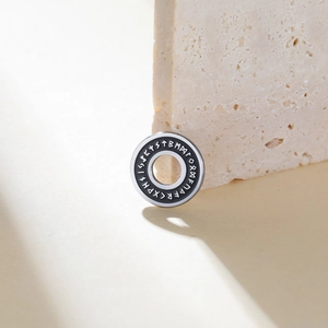 Macro shot of 15mm stainless steel Norse Rune pendant with black enamel finish